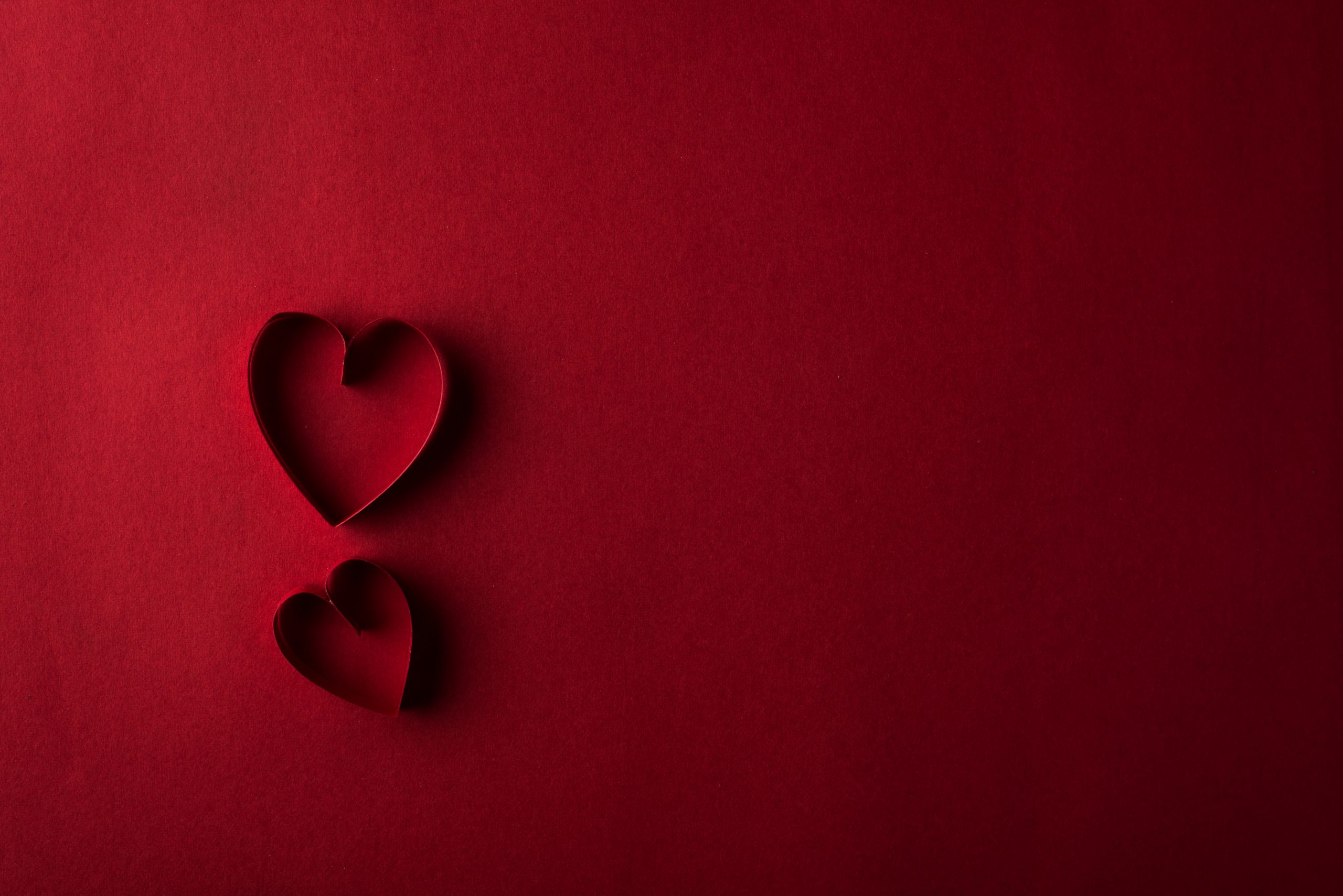 Two Red Hearts Against Red Background